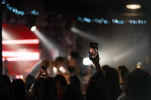 persona vicino su di registrazione video con smartphone durante un' concerto. foto