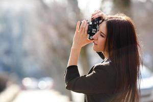 bellissimo femmina fotografo in posa con telecamera foto