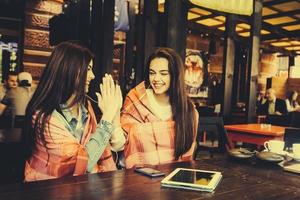 Due giovane e bellissimo ragazze avendo divertimento nel bar foto