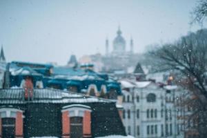 abbondante nevicata al di sopra di il città con il tetti foto