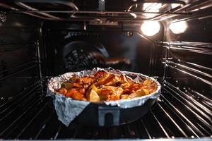 al forno patate con carota e altro spezie nel torrefazione padella. foto