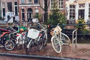 biciclette liner un' ponte al di sopra di il canali di amsterdam foto