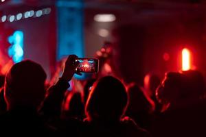 persona vicino su di registrazione video con smartphone durante un' concerto. foto