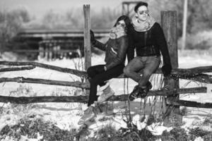 giovane coppia seduta su vecchio recinto foto