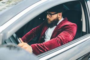 uomo con barba guida un' auto foto