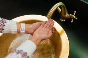 vicino su foto di donna lavaggi sua mani con sapone e acqua.