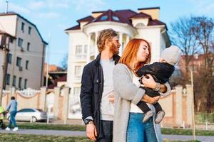 contento mamma papà e figlio abbracciare nel il parco foto