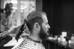 maestro nel barbiere fa Uomini taglio di capelli con capelli clipper foto