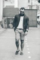 uomo barbuto alla moda cammina attraverso la città foto