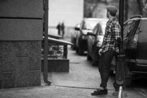 l'uomo con gli stivali autentici e i jeans a cimosa sullo sfondo della città vecchia foto