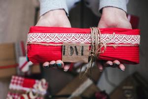 il ragazza detiene nel mani affascinante regalo per sua amato uno foto