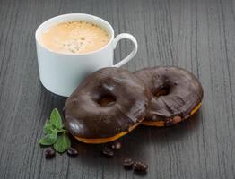 caffè con cioccolato ciambelle su di legno sfondo foto