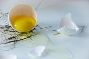 bianca uovo è rotte, il conchiglia è su il tavolo. leggero sfondo foto