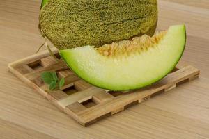 melone su di legno tavola e di legno sfondo foto