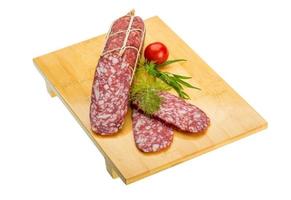 salame su di legno tavola e bianca sfondo foto