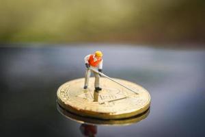 figurine Lavorando estrazione bitcoin d'oro scavando su virtuale criptovaluta bitcoin estrazione concetto foto