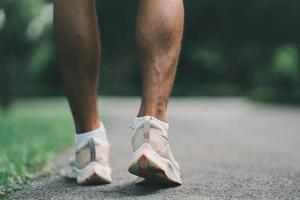 vicino su di in esecuzione scarpe o piedi sportivo corridore in forma corpo prima inizio per in esecuzione o jogging nel il giardino avere Di Più albero e pulito aria, esercizio a parco. sport salutare in esecuzione concetto. foto