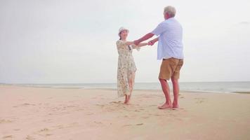 contento coppie in piedi e Tenere mani insieme su il spiaggia. foto