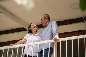 contento asiatico coppie in piedi a il balcone e parlando insieme. foto