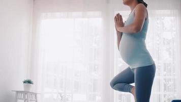 asiatico incinta donna fare yoga esercizi a casa. foto