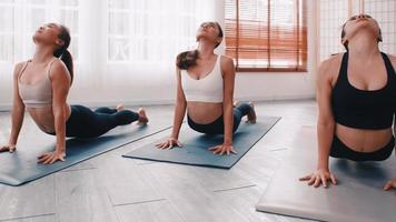 gruppo di asiatico donne allungamento nel yoga classe. gruppo di ragazze fare pilates esercizi a il palestra. foto