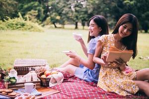 Due femmina amici godendo picnic insieme nel un' parco. foto