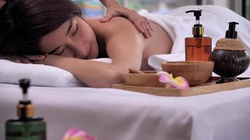 il massaggio terapista massaggio su il indietro di giovane asiatico donna con aroma essenziale olio cura della pelle a terme salone. foto