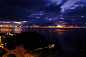 ardente tramonto dietro a buio nuvole a tigre spiaggia foto