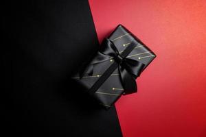 confezione regalo nera con nastri neri isolati su sfondo nero foto