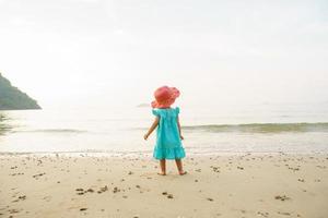 adorabile poco ragazza a tropicale bianca sabbia spiaggia foto