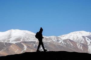 silhouette di donna escursionista sta su il roccia nel il bellissimo montagne Visualizza di nevoso tso moriri lago nel leh ladakh India, successo concetto foto