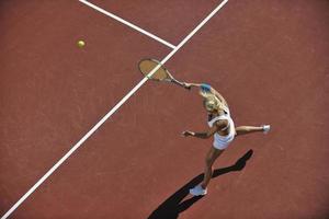 giovane donna giocare a tennis all'aperto foto