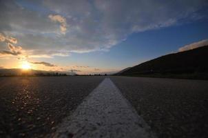 strada di campagna avventura con bellissimo tramonto foto