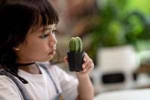 ragazzo delicatamente tocchi il nuovo stelo di il cactus lui cresce con cura natura formazione scolastica, montessori, e osservazione abilità concetti. foto