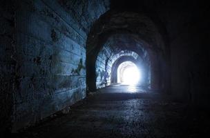 uscita blu incandescente dal buio tunnel abbandonato