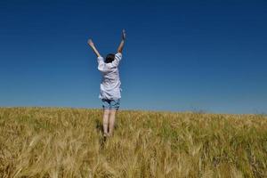 giovane donna nel campo di grano in estate foto