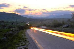 strada di campagna avventura con bellissimo tramonto foto