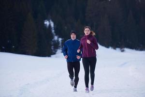 coppia jogging al di fuori su neve foto