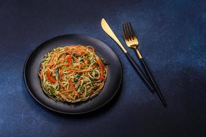 fresco insalata di affettato magro strisce di carota e zucchine su un' calcestruzzo sfondo foto