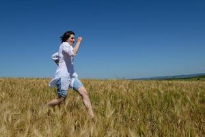 giovane donna nel campo di grano in estate foto