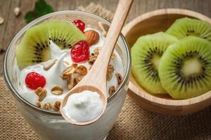 greco Yogurt nel un' bicchiere con Kiwi - su di legno sfondo foto