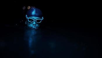 autentico triatleta nuotatore avendo un' rompere durante difficile formazione su notte neon gel leggero foto