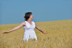 giovane donna nel campo di grano in estate foto