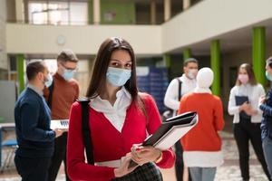 ritratto di multietnico studenti gruppo a Università indossare protettivo viso maschera foto
