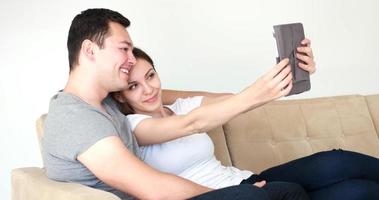 giovane coppia utilizzando digitale tavoletta a casa foto