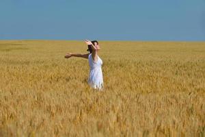 giovane donna nel campo di grano in estate foto