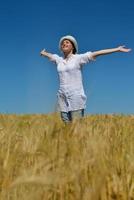 giovane donna nel campo di grano in estate foto