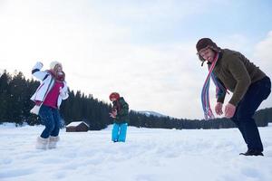 contento famiglia giocando insieme nel neve a inverno foto