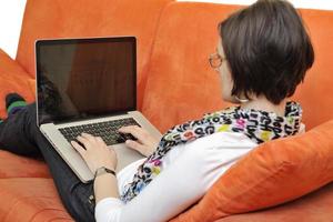 donna utilizzando un' il computer portatile computer a casa foto