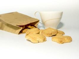biscotti in un sacchetto di carta e una tazza di caffè foto
